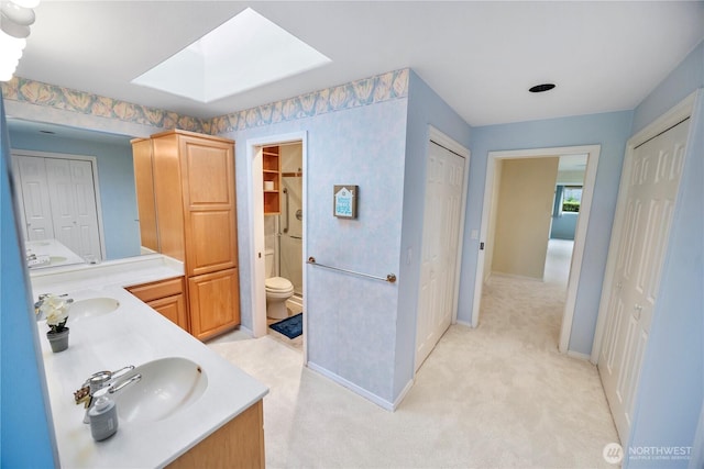 full bath featuring a skylight, a sink, and a closet