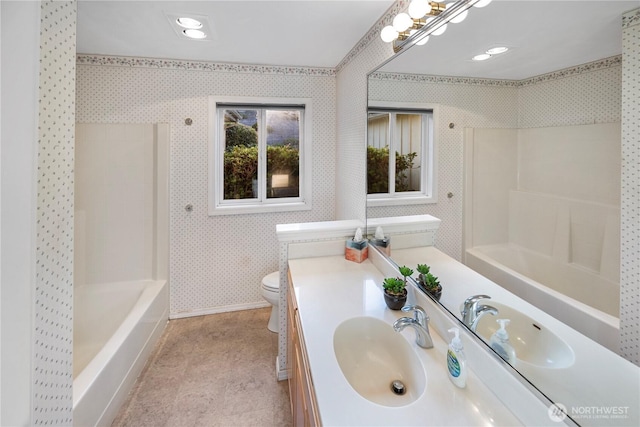 full bath featuring toilet, wallpapered walls, shower / bath combination, and vanity