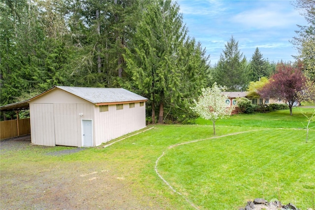 view of yard featuring an outbuilding, a carport, and driveway