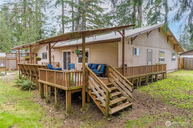 rear view of property with a deck, fence, and an outdoor hangout area