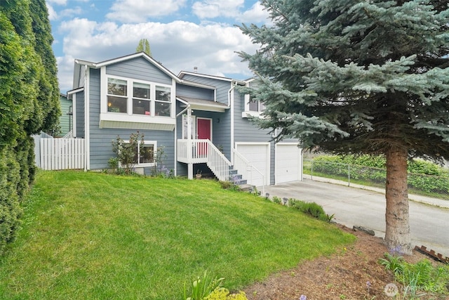 split foyer home featuring an attached garage, fence, driveway, and a front yard