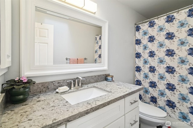 bathroom featuring toilet, a shower with shower curtain, and vanity