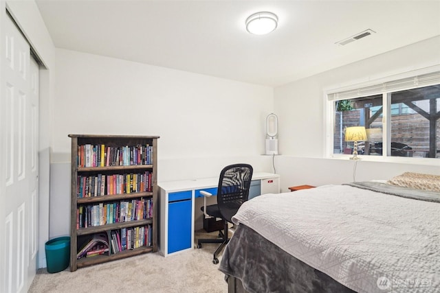 bedroom with visible vents, a closet, and light colored carpet