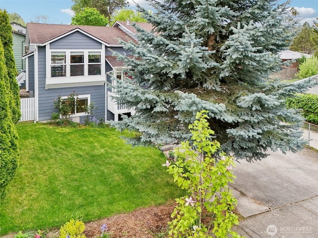 view of side of home featuring a yard and fence