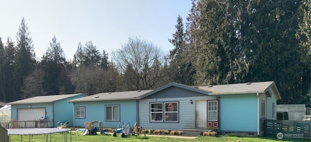 view of front of house featuring an outdoor structure, a front lawn, and a garage