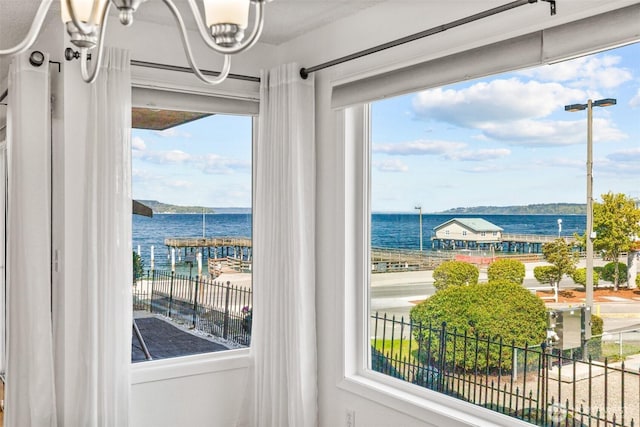 doorway to outside featuring an inviting chandelier and a water view
