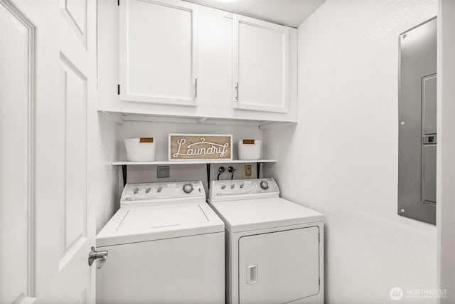 washroom featuring cabinet space, electric panel, and washing machine and clothes dryer