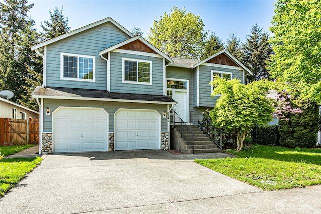 8342 49th Loop SE, Olympia, WA 98513 - raised ranch featuring concrete driveway, fence, a garage, and stone siding