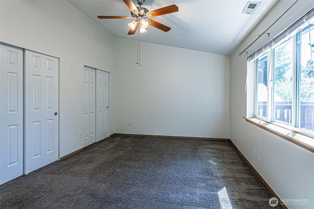 8342 49th Loop SE, Olympia, WA 98513 - unfurnished bedroom featuring baseboards, visible vents, vaulted ceiling, dark carpet, and multiple closets
