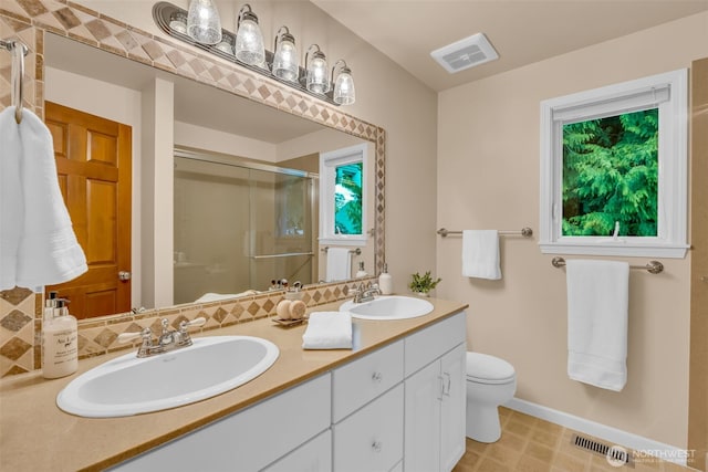 bathroom featuring double vanity, visible vents, a shower stall, and a sink