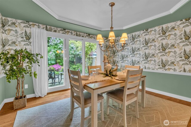 dining room with wood finished floors, a notable chandelier, and wallpapered walls