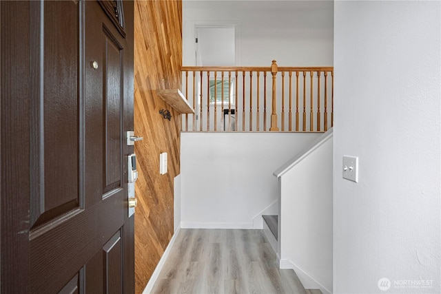 entryway featuring baseboards, stairs, and wood finished floors