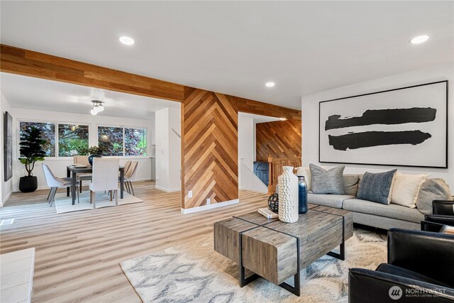 living area featuring baseboards, wooden walls, light wood finished floors, and recessed lighting