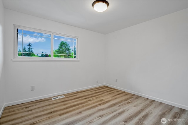 unfurnished room with light wood-style flooring, baseboards, and visible vents