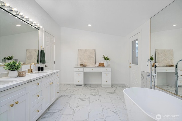 bathroom with marble finish floor, vanity, recessed lighting, a freestanding bath, and baseboards