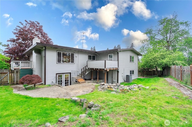 back of property with a yard, a chimney, french doors, cooling unit, and a fenced backyard