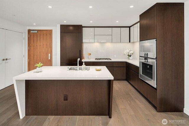 kitchen with gas cooktop, a sink, modern cabinets, and light countertops