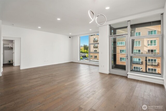 interior space featuring recessed lighting, baseboards, and dark wood finished floors