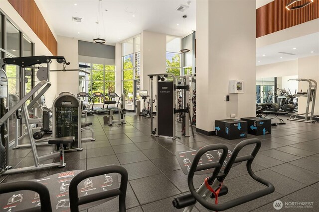 gym with a towering ceiling and visible vents