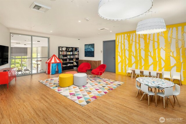 recreation room with recessed lighting, wood finished floors, and visible vents