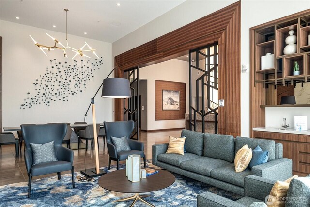 living room with stairs, indoor bar, an inviting chandelier, and recessed lighting
