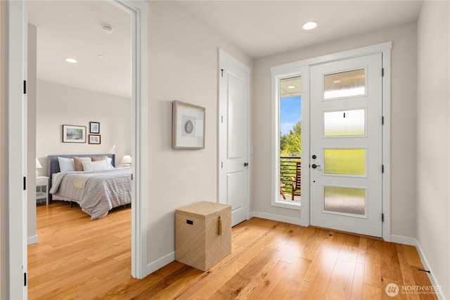 doorway with light wood-type flooring, baseboards, and recessed lighting