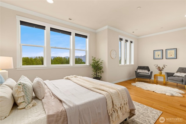 bedroom featuring multiple windows, wood finished floors, baseboards, ornamental molding, and recessed lighting