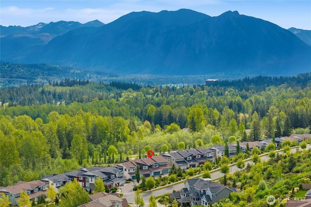 aerial perspective of suburban area featuring mountains and a heavily wooded area