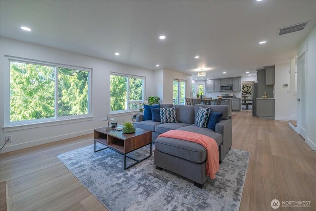 living room with baseboards, recessed lighting, and light wood finished floors