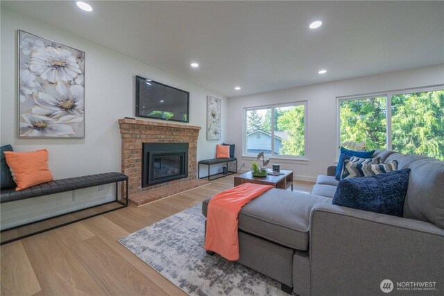 living area with wood finished floors, recessed lighting, and a fireplace