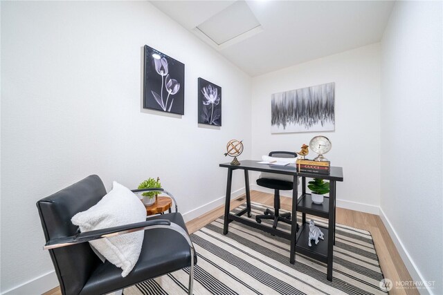 office with light wood-style floors, baseboards, and attic access