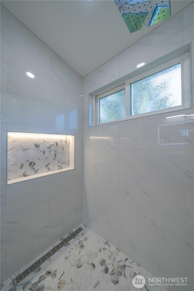 full bath featuring a tile shower and tile patterned floors