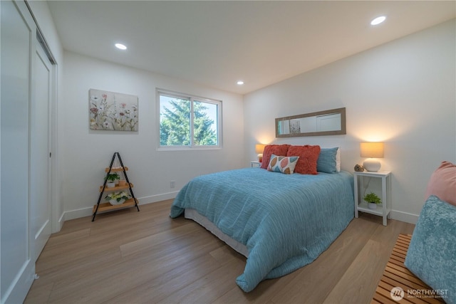 bedroom featuring baseboards, light wood-style flooring, recessed lighting, and a closet