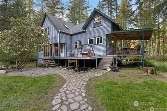 back of house featuring a lawn, a wooden deck, and stairway
