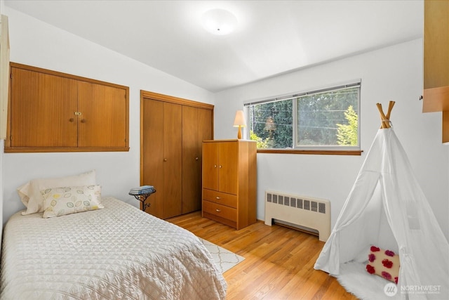 bedroom featuring radiator, a closet, and light wood-type flooring