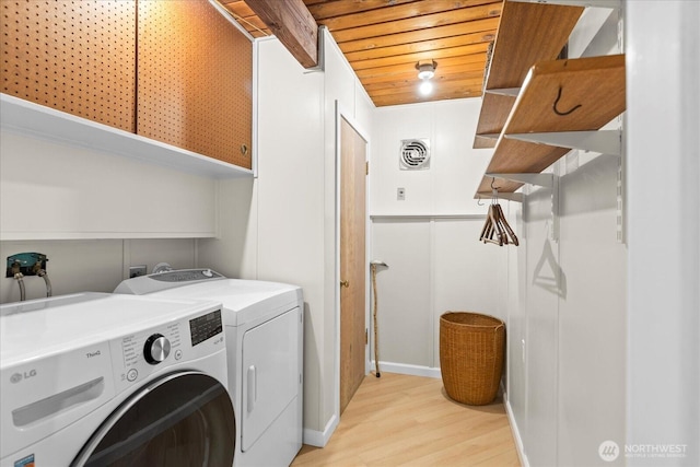 washroom with visible vents, baseboards, light wood-type flooring, wood ceiling, and separate washer and dryer