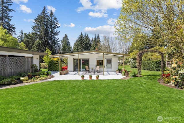 back of property with a yard, fence, and a patio area
