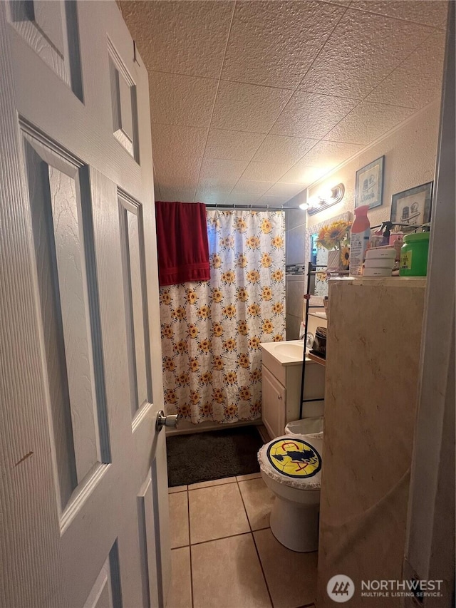 full bathroom with curtained shower, toilet, tile patterned flooring, and vanity