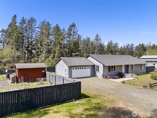 single story home featuring dirt driveway, fence, and a garage