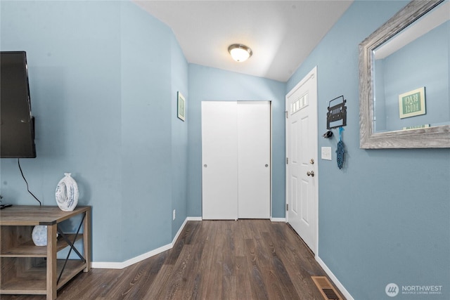corridor featuring baseboards, visible vents, and wood finished floors