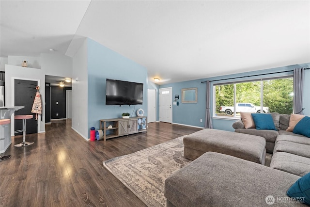 living room featuring baseboards, wood finished floors, and lofted ceiling