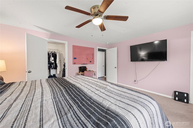 bedroom featuring a ceiling fan, baseboards, a closet, a spacious closet, and carpet