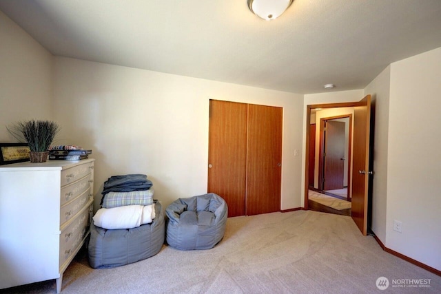 sitting room featuring light colored carpet and baseboards
