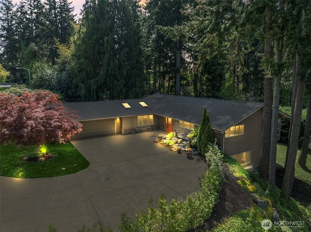 12105 SE 23rd St, Bellevue, WA 98005 - view of front of home with a garage, driveway, and a forest view