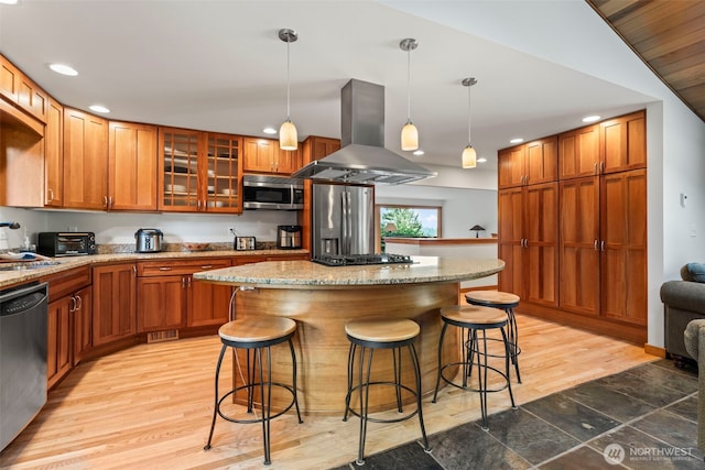 12105 SE 23rd St, Bellevue, WA 98005 - kitchen with glass insert cabinets, a kitchen breakfast bar, island range hood, a center island, and stainless steel appliances