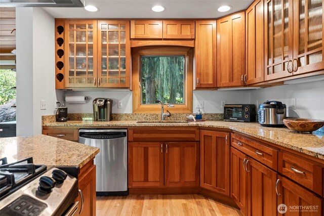 12105 SE 23rd St, Bellevue, WA 98005 - kitchen with a sink, light stone counters, light wood finished floors, glass insert cabinets, and stainless steel appliances