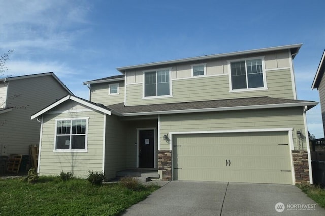traditional home featuring a garage, driveway, and stone siding