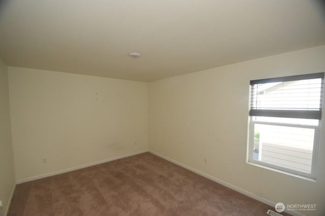 empty room with baseboards and carpet