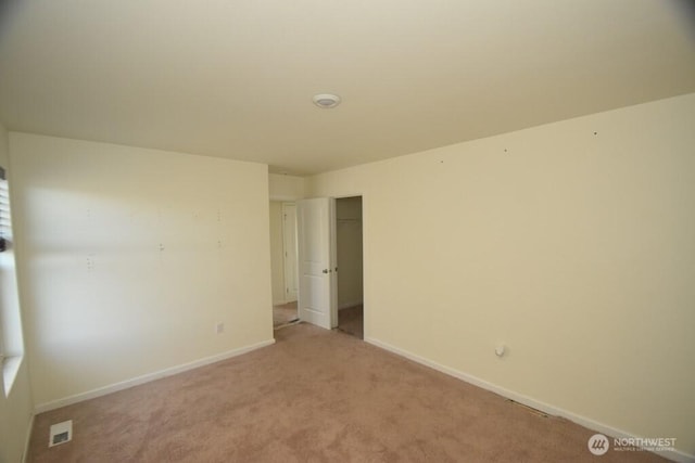 unfurnished bedroom with baseboards, visible vents, light carpet, and a closet
