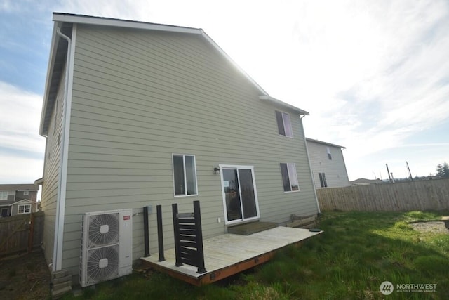 back of property with ac unit, fence, a yard, and a wooden deck